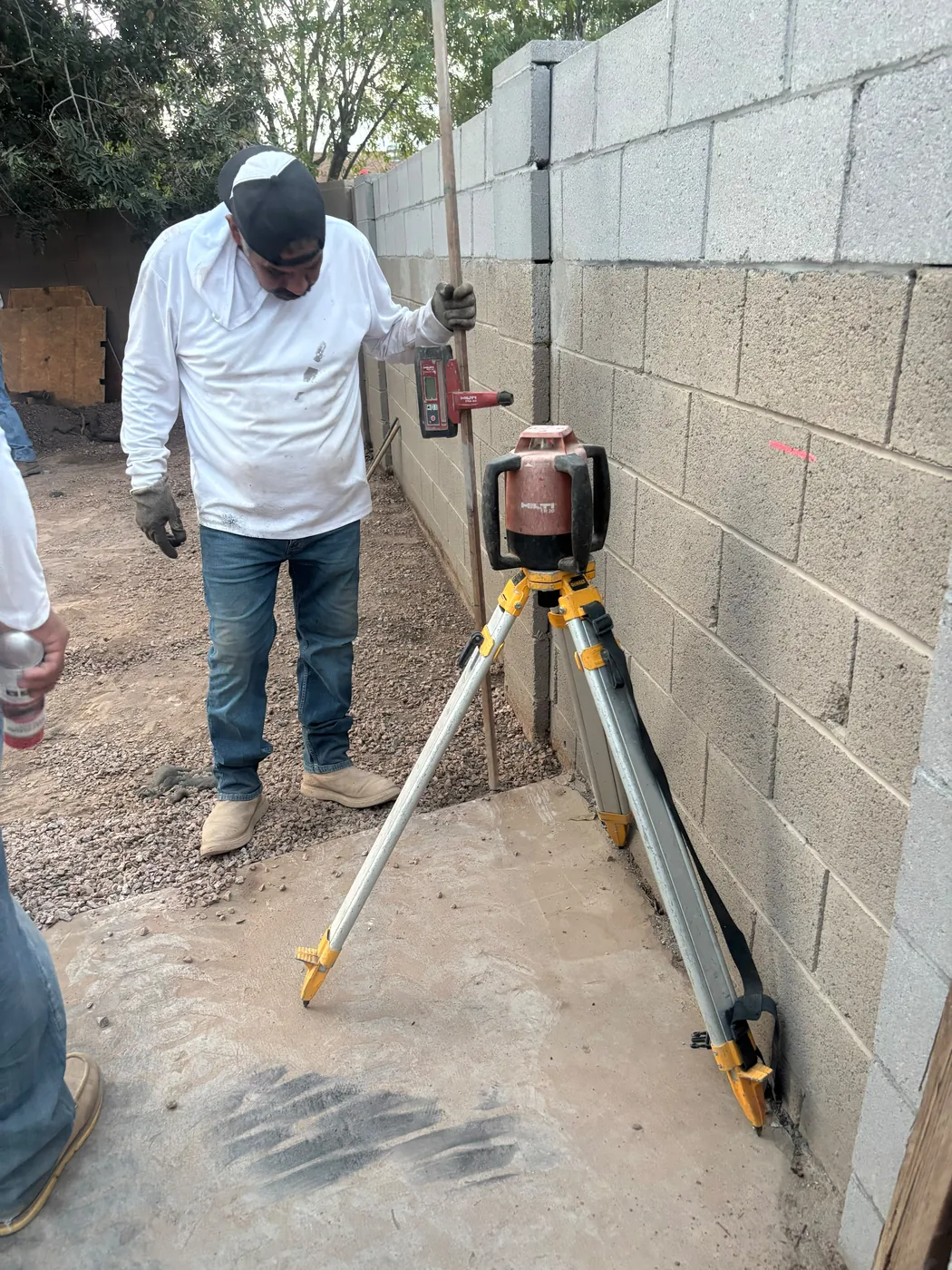 Laser level set up for concrete layout at a block wall