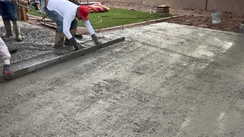 Crew screeding a fresh concrete pour level